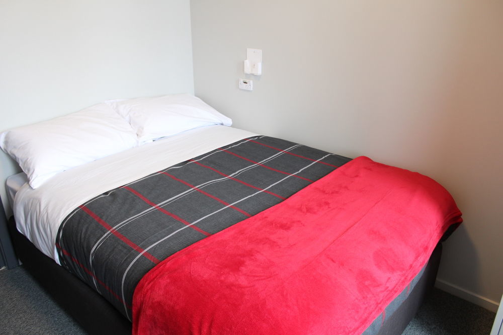 Hostel Urbanz Christchurch Exterior foto A bed with a throw